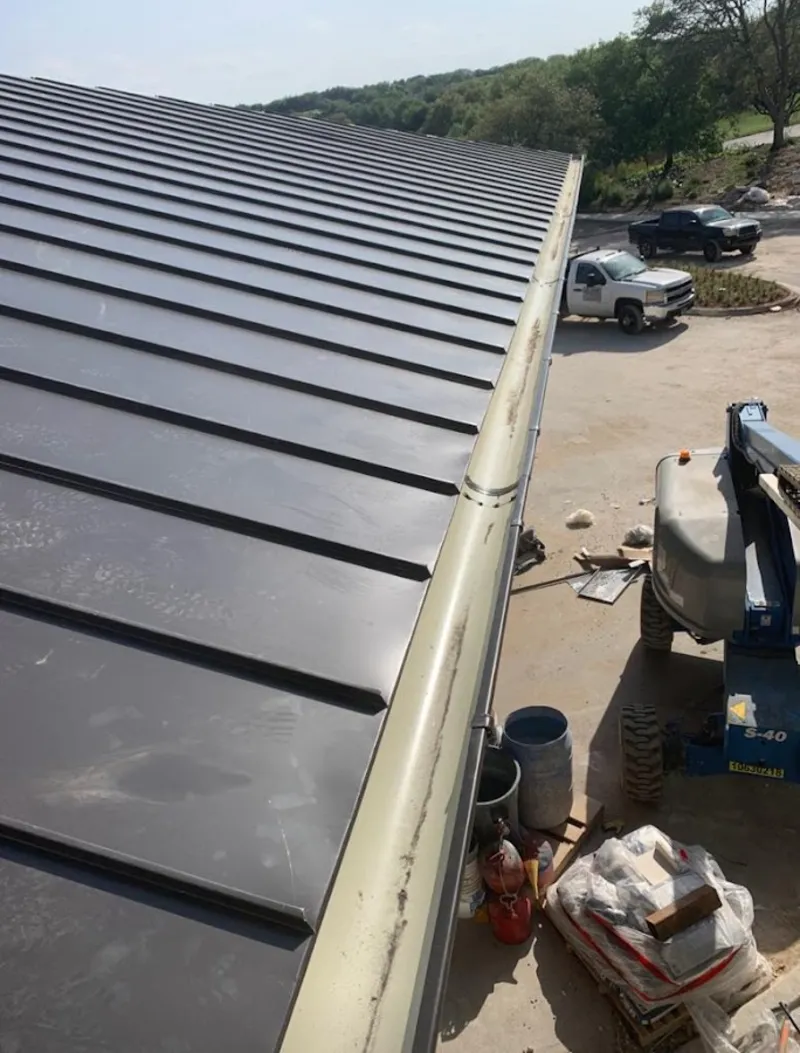 Standing seam panel and gutter detail on a metal roofing jobsite in Chenango